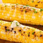 corn on the cob calories. image features 3 ear of corn that have been grilled and topped with butter