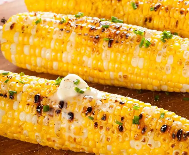 corn on the cob calories. image features 3 ear of corn that have been grilled and topped with butter