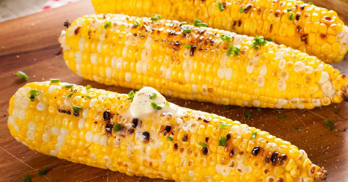 corn on the cob calories. image features 3 ear of corn that have been grilled and topped with butter